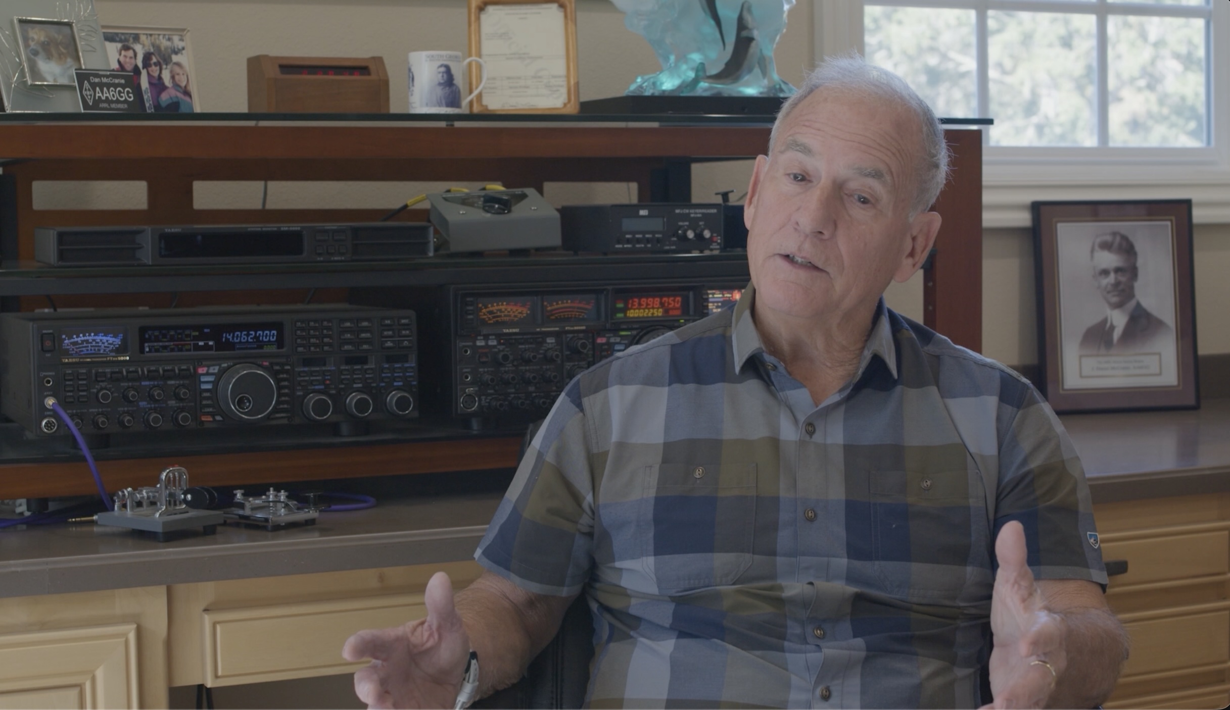 Interview portrait of a man seated in front of ham radio equipment for Cat's Whisker